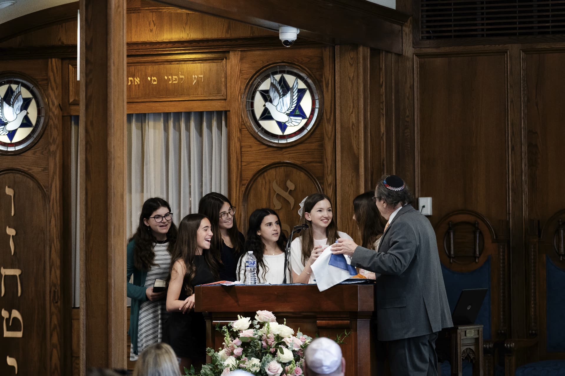 Teens celebrating on the bimah with the rabbi at Adat Shalom